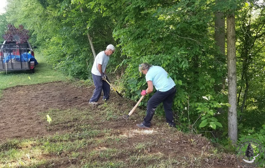 Rodney and Allison Pearson clearing the vegetation from the Redbud planting area.