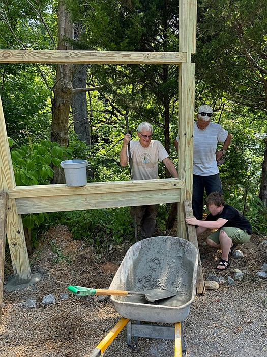 Our Favorite Helper Handley Finishes the Cement on the Newly Installed Kiosk Frame.
